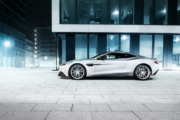 Samochód aston martin w środku nocnego miasta