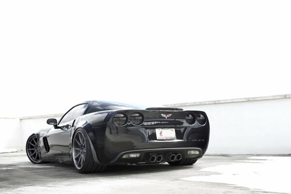 Czarny samochód Chevrolet corvette na tle białych ścian