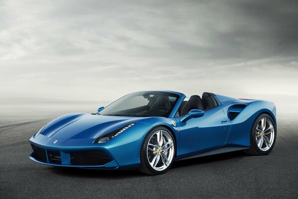Niebieskie Ferrari wyścigowe na drodze we mgle