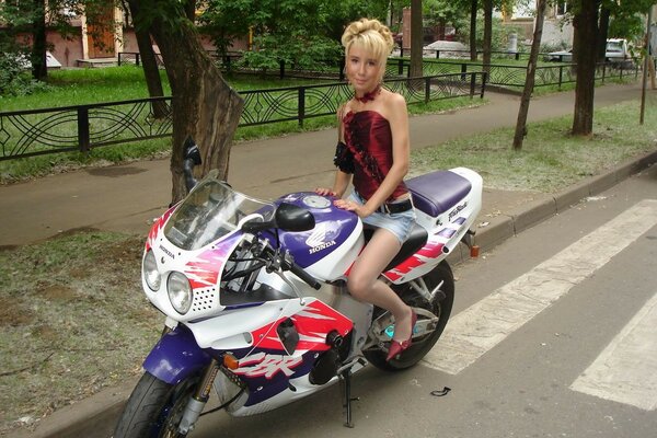 Kobieta w minispódniczce na motocyklu na drodze