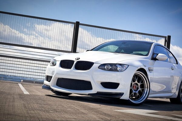 Biały samochód bmw M3 Coupe na niskoprofilowych oponach