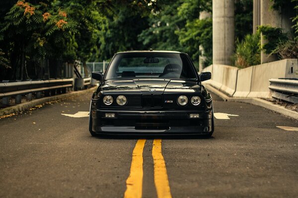 BMW e30 czarne na drodze z przodu