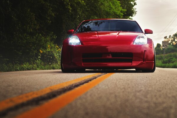 Красный nissan 350z на дороге вид спереди