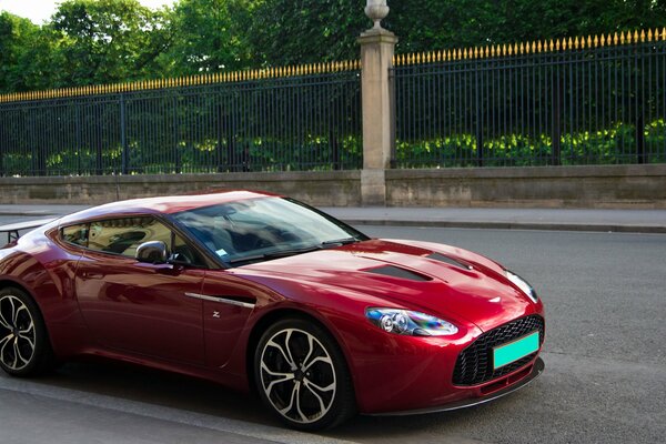 Ciemnoczerwony Aston Martin na drodze
