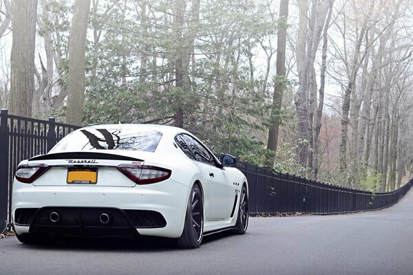 Białe Maserati Włochy na tle ogrodzenia