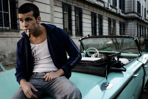 Aktor Mario Casas siedzi i pali w samochodzie