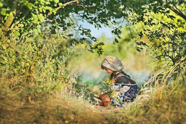 Девочка летом на природе с корзинкой цветов