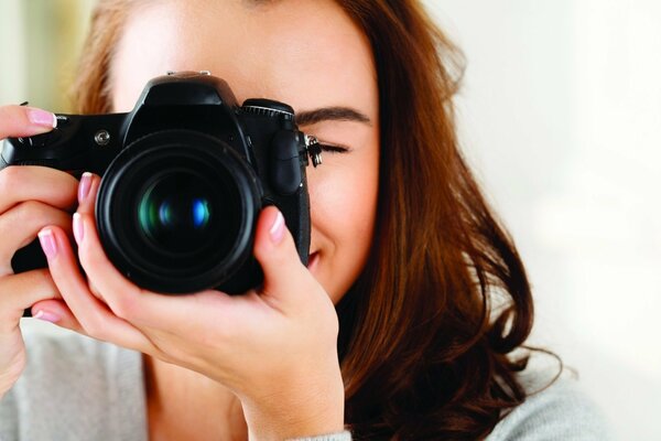 Девушка фотограф смотрит в объектив
