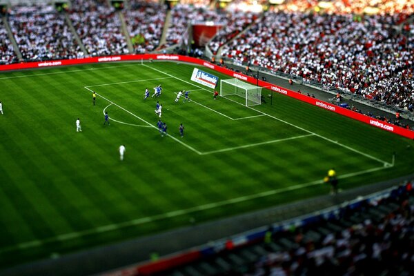 Piłkarze na stadionie, prowadzą piłkę do bramki