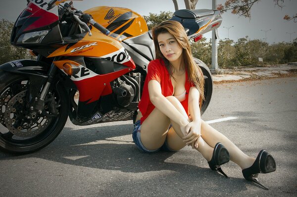 Azjatka pozuje na tle motobike