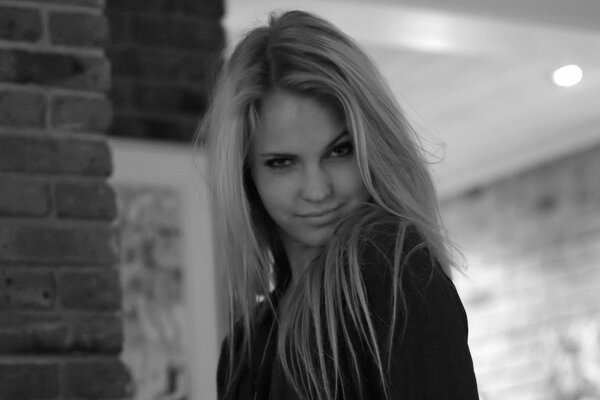Czarno-białe zdjęcie modelki Emily Marie. Na zdjęciu dziewczyna ładnie zmrużyła oczy