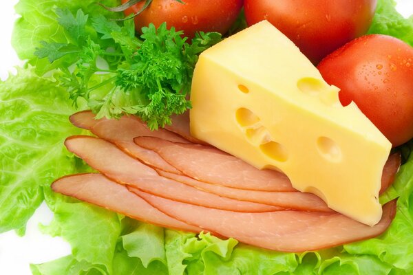 Кусок сыра и балык на зелени