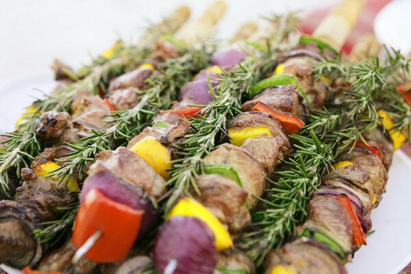 Вкусное мясо с овощами на шпажках и веточки зелени
