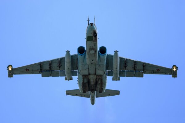 Opancerzony poddźwiękowy samolot szturmowy Su-25 leci na błękitnym niebie