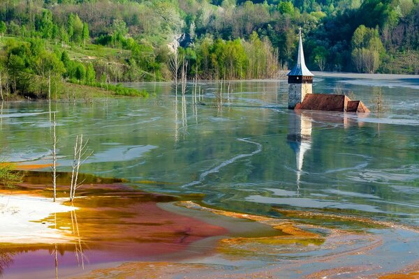 Потонувшая в озере церковь, окруженная водой и лесом